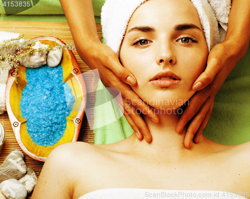 Image of stock photo attractive lady getting spa treatment in salon, close up asian hands on face