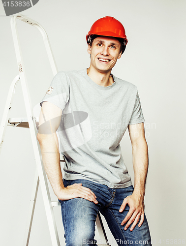 Image of young real hard worker man isolated on white background on ladder smiling posing, business concept