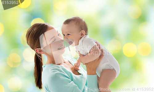 Image of happy mother with little baby over green lights