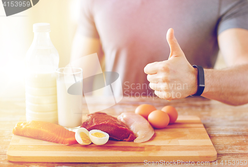 Image of man with food  rich in protein showing thumbs up