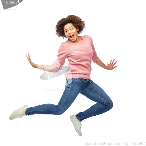 Image of happy african american woman jumping over white