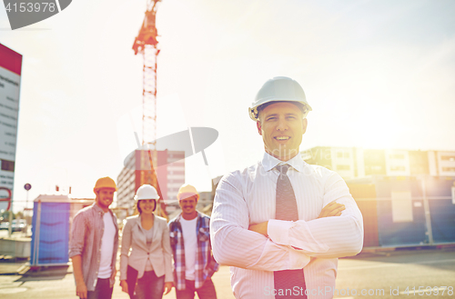 Image of happy builders and architect at construction site