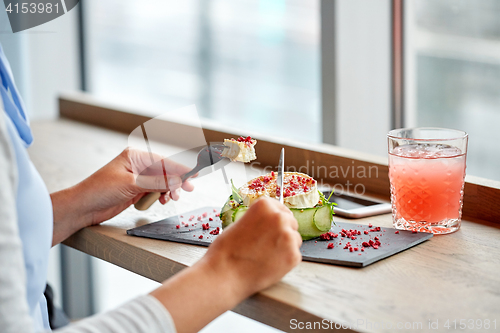 Image of woman eating goat cheese salad at restaurant