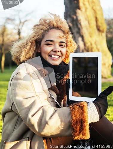 Image of young cute blond african american girl student holding tablet and smiling, lifestyle people concept