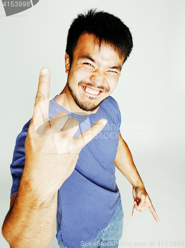 Image of young cute asian man on white background gesturing emotional, pointing, smiling, lifestyle people concept