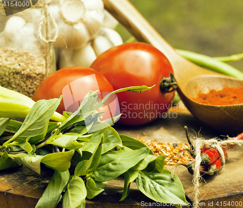 Image of vegetables on wooden kitchen with spicies, tomato, chilli, green