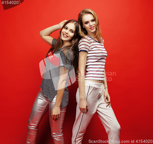 Image of two best friends teenage girls together having fun, posing emotional on red background, besties happy smiling, lifestyle people concept