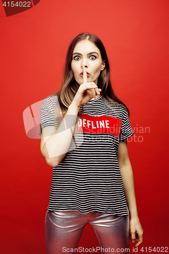 Image of young pretty emitonal posing teenage girl on bright red background, happy smiling lifestyle people concept