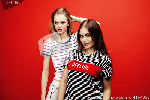 Image of two best friends teenage girls together having fun, posing emotional on red background, besties happy smiling, lifestyle people concept