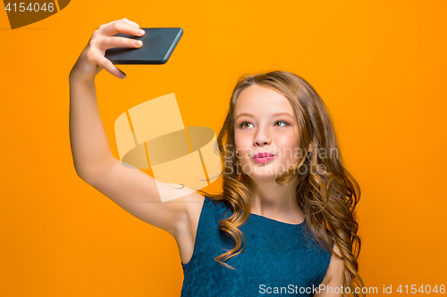 Image of The face of playful happy teen girl with phone