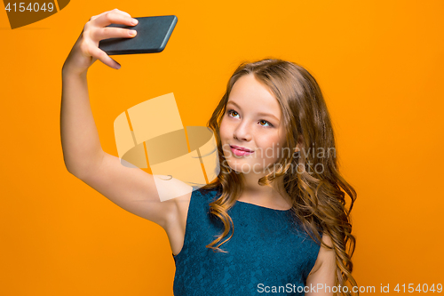 Image of The face of playful happy teen girl with phone