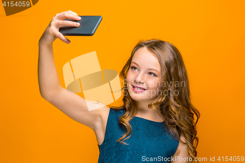 Image of The face of playful happy teen girl with phone