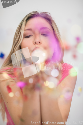 Image of woman blowing confetti in the air