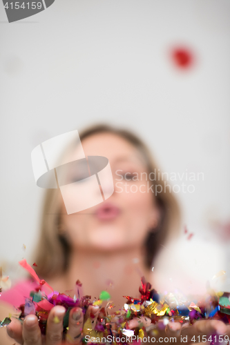 Image of woman blowing confetti in the air