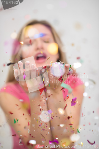 Image of woman blowing confetti in the air