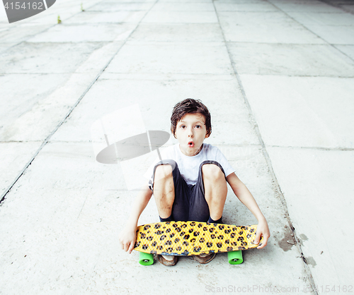 Image of little cute boy with skateboard on playground alone training, copyspace, lifestyle people concept