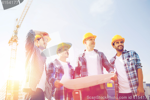 Image of group of builders with tablet pc and blueprint