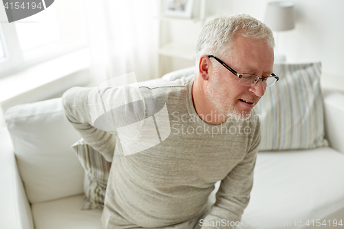 Image of unhappy senior man suffering from backache at home