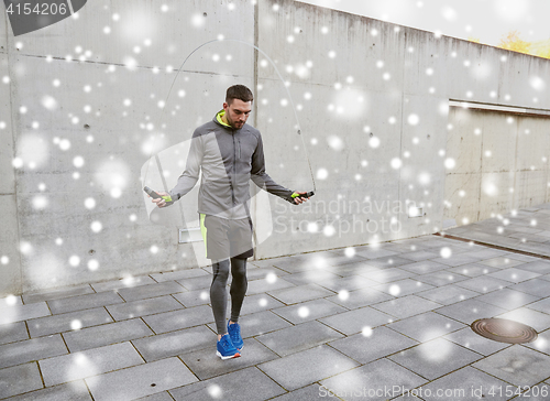 Image of man exercising with jump-rope outdoors