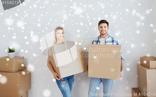 Image of smiling couple with big boxes moving to new home