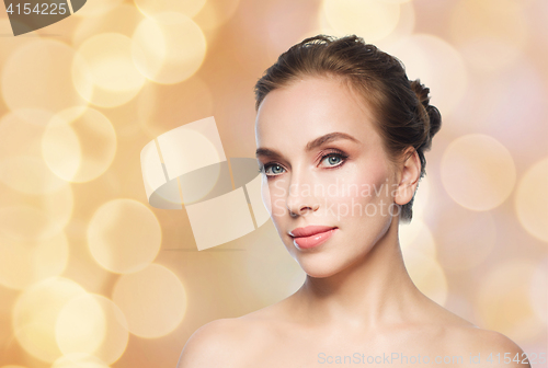 Image of beautiful young woman face over holidays lights