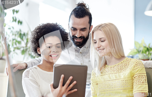 Image of happy creative team with tablet pc in office