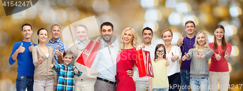 Image of happy people with shopping bags showing thumbs up