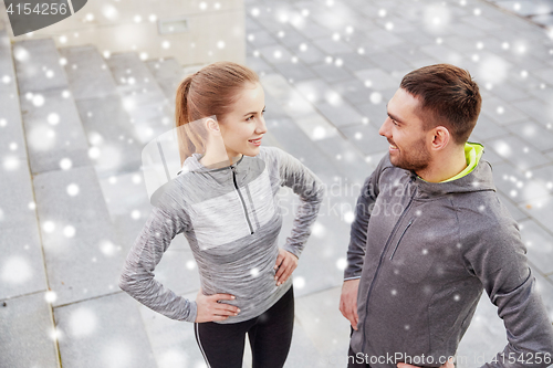 Image of happy couple of sportsmen outdoors on city street