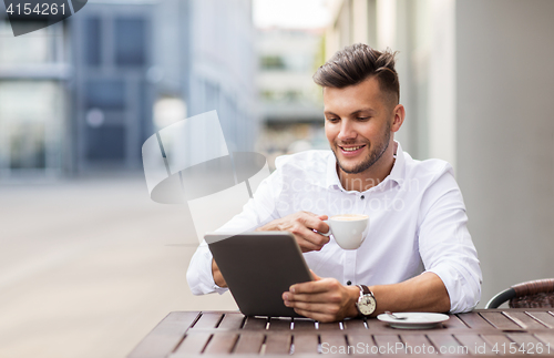 Image of man with tablet pc and coffee at city cafe