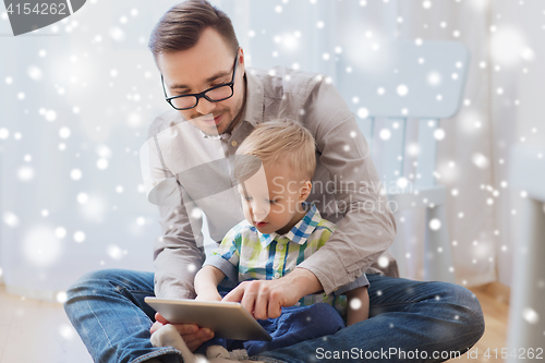 Image of father and son with tablet pc playing at home