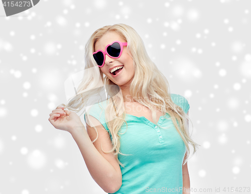 Image of happy woman or teenager in heart shaped sunglasses