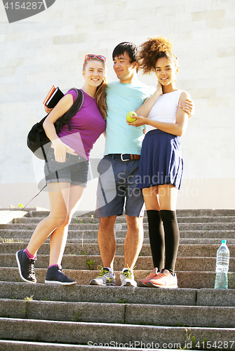 Image of cute group of teenages at the building of university with books 