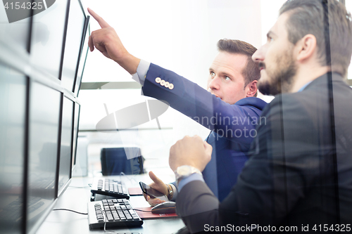 Image of Stock traders looking at computer screens.