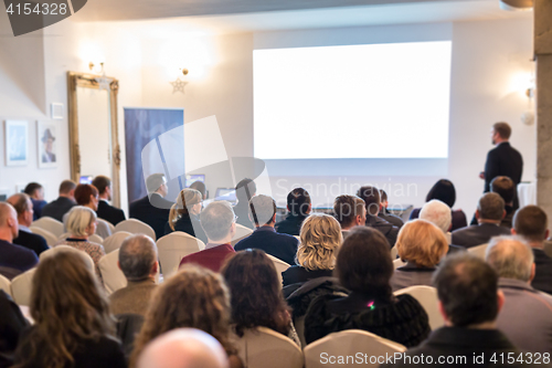 Image of Public speaker giving talk at Business Event.