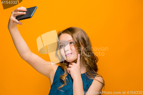 Image of The face of playful happy teen girl with phone