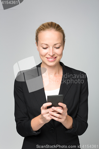 Image of Beautiful young caucasian businesswoman using mobile phone.