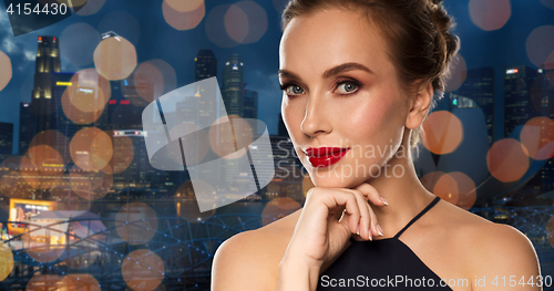 Image of beautiful woman in black over dark background