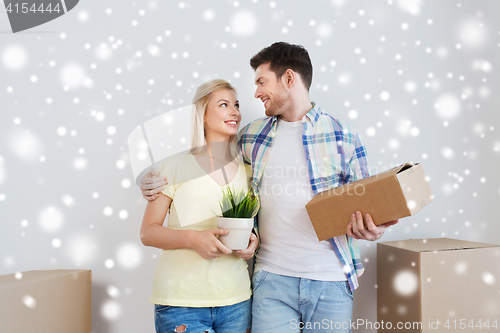 Image of smiling couple with boxes moving to new home