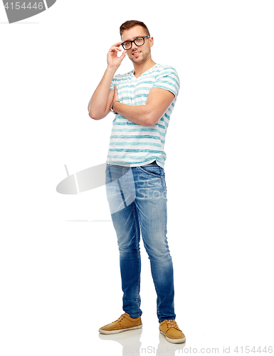 Image of smiling young man in eyeglasses over white