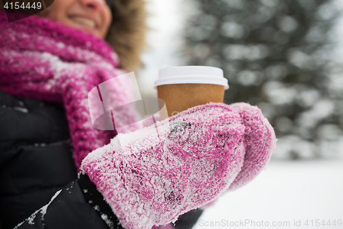 Image of close up of hand with coffee outdoors in winter