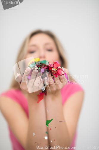 Image of woman blowing confetti in the air