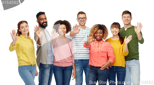 Image of international group of happy people waving hand