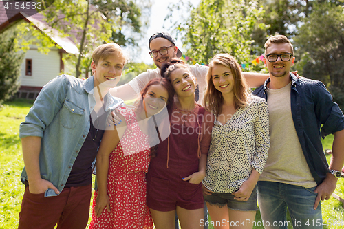 Image of happy teenage friends hugging at summer garden