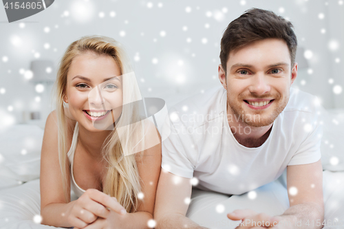 Image of happy couple lying in bed at home