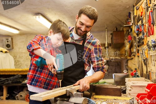 Image of father and son with drill working at workshop
