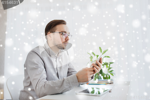 Image of creative male office worker texting on smartphone