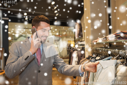 Image of happy man calling on smartphone at clothing store