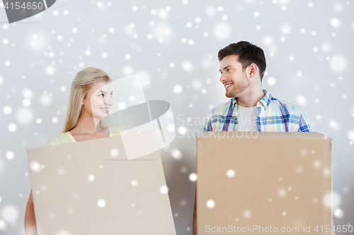 Image of smiling couple with big boxes moving to new home