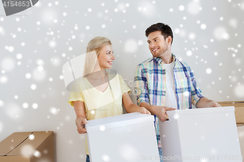 Image of smiling couple with big boxes moving to new home