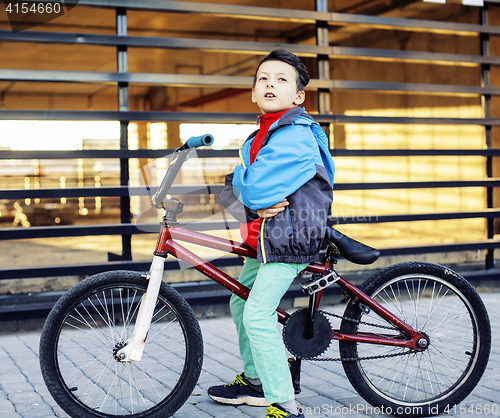 Image of young kid on cool bmx bicycle riding outside, lifestyle people c